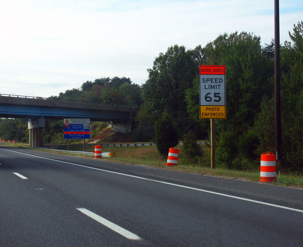 Highway work area with speed limit signage and channelizer drums